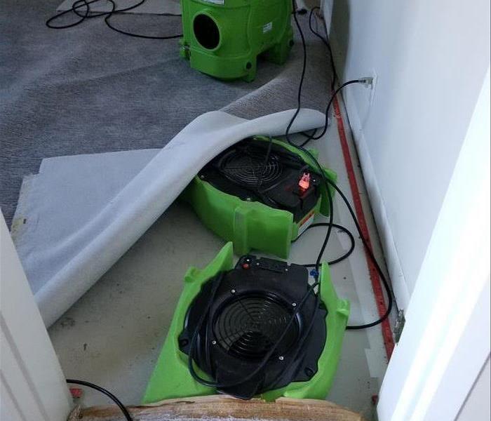 Drying equipment on top of and under a carpet.